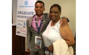 Kendall Austin waits in the hotel lobby with his grandmother, Sandra Austin, chairwoman of the DeKalb County Democratic Party, before boarding the delegate bus to the Wells-Fargo Center in Philadelphia.
