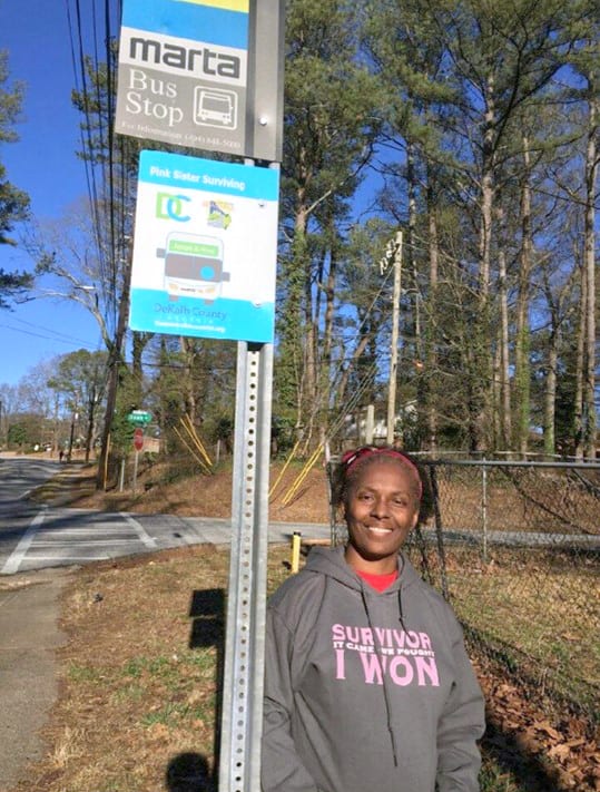 Priscilla Davenport, breast cancer survivor, stands in front of her adopted MARTA bus stop she has sponsored for the past two years. 