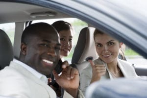 Multi-ethnic businesspeople sharing a car