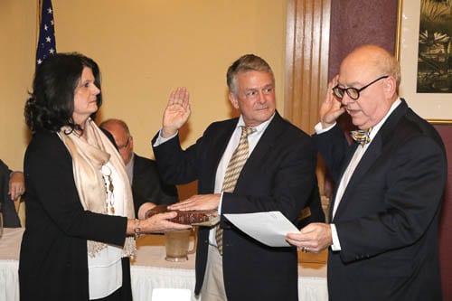 Vince Evans is sworn in as his wife, Cyndi, holds the Bible before Chief Superior Court Judge David Irwin. 