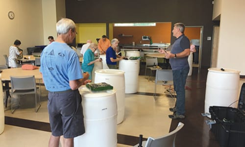 Citizens complete rain barrels to take home at a Keep DeKalb Beautiful workshop. Photo provided