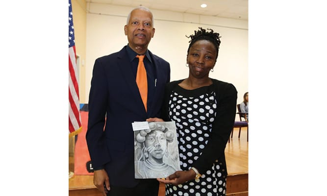 Congressman Hank  Johnson stands with grand prize winner, Arantza Pena Popo’s mother Maria Popo, and the winning piece “Cultural Portrait” during the reception. Arantza was attending a college preparatory class and could not attend the Saturday event.