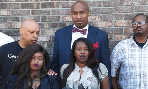 Attorney Mawuli Davis (back), community organizers and Tilson’s family held a news conference on May 4 to urge witnesses to come forward. Photo by Glenn L. Morgan