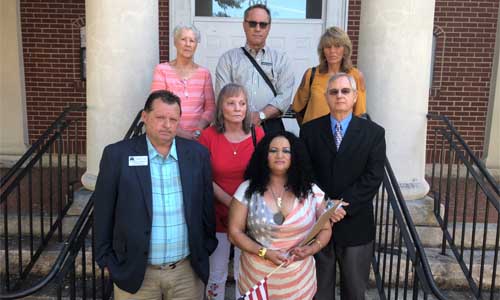 Josie Dean (holding the American flag) stands with supporters at her June 26 news conference. Photo by Glenn L. Morgan