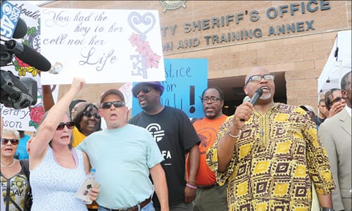 Derrick Boazman ( holding the microphone) is flanked by Jamie Henry’s parents at left. Photos by Glenn L. Morgan